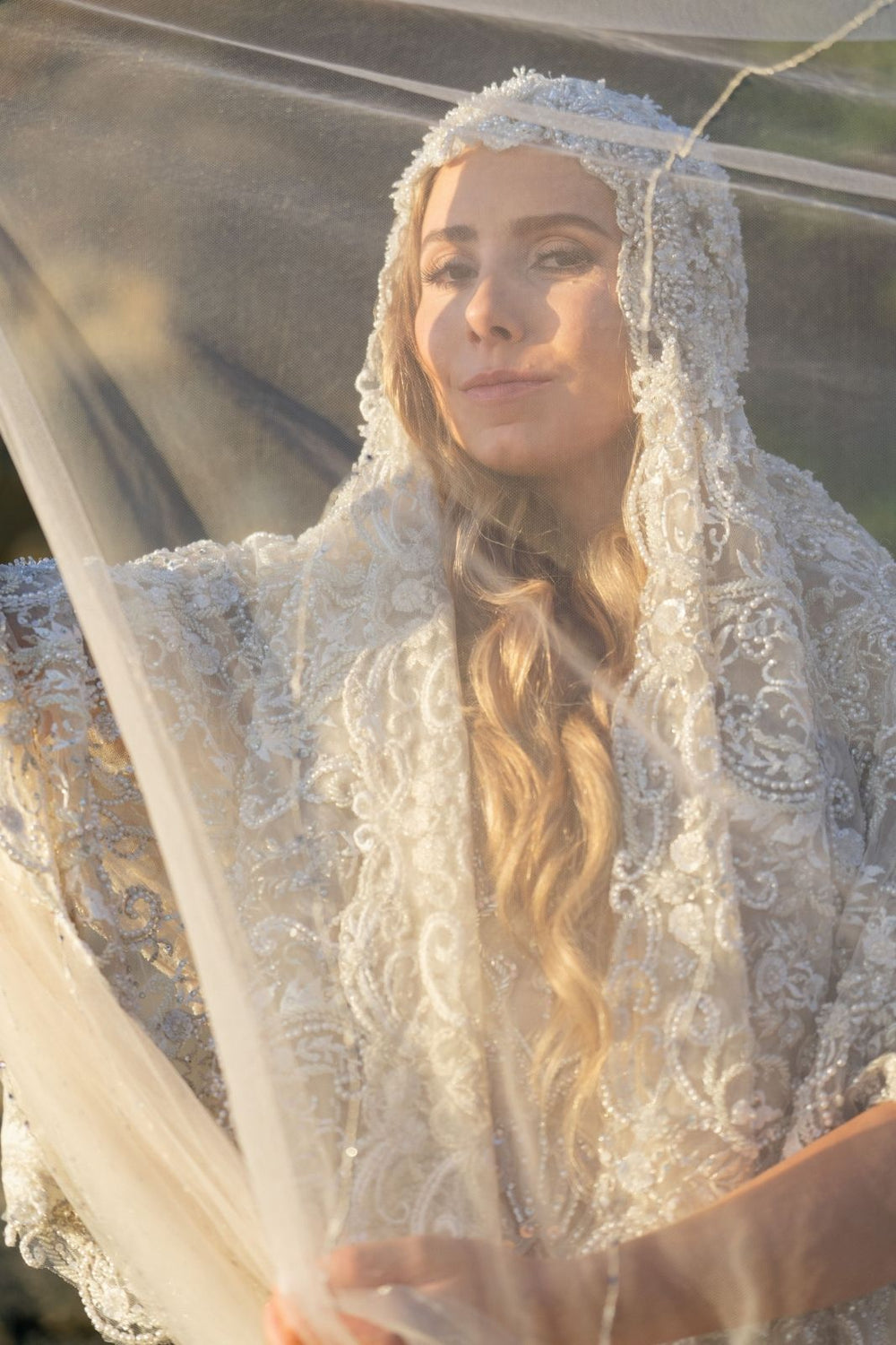 Detail of the Gigi lace veil softly framing the bride's face with sculptural elegance