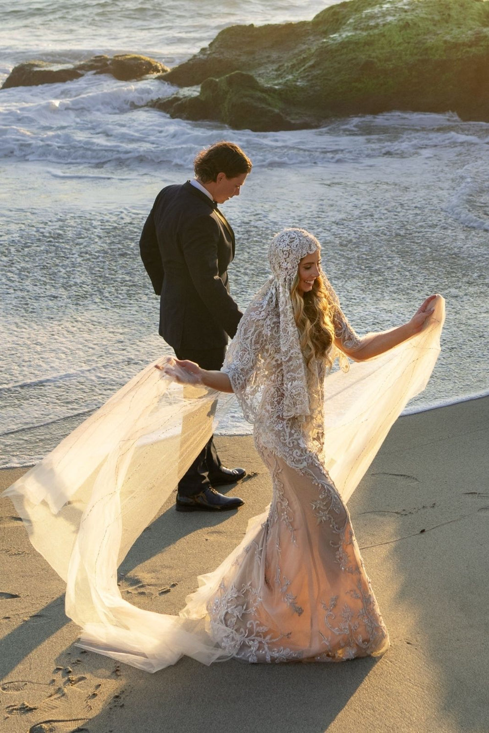 Full-length view of bride wearing the Gigi statement bridal veil with flowing lace and sculptural headpiece
