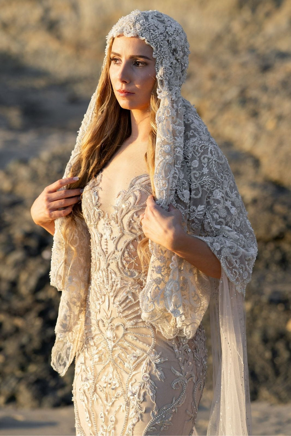 Bride wearing the Gigi statement lace veil during a beach wedding ceremony with the veil catching the light