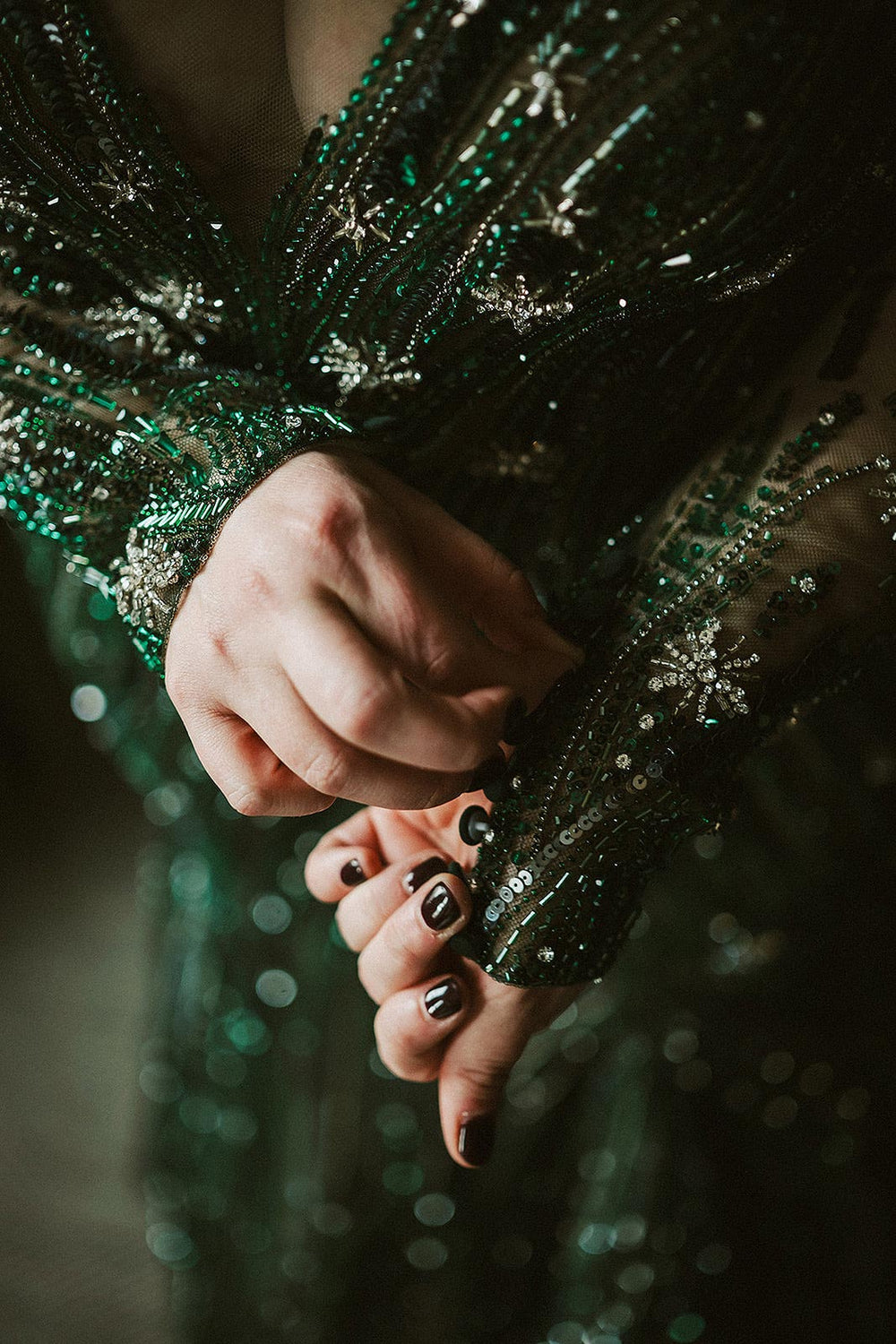 close-up of the beaded sleeve cuff on the Jessica green wedding gown by Angela Kim Couture, showing intricate green glass bead, crystal, and snowflake-motif hand embroidery