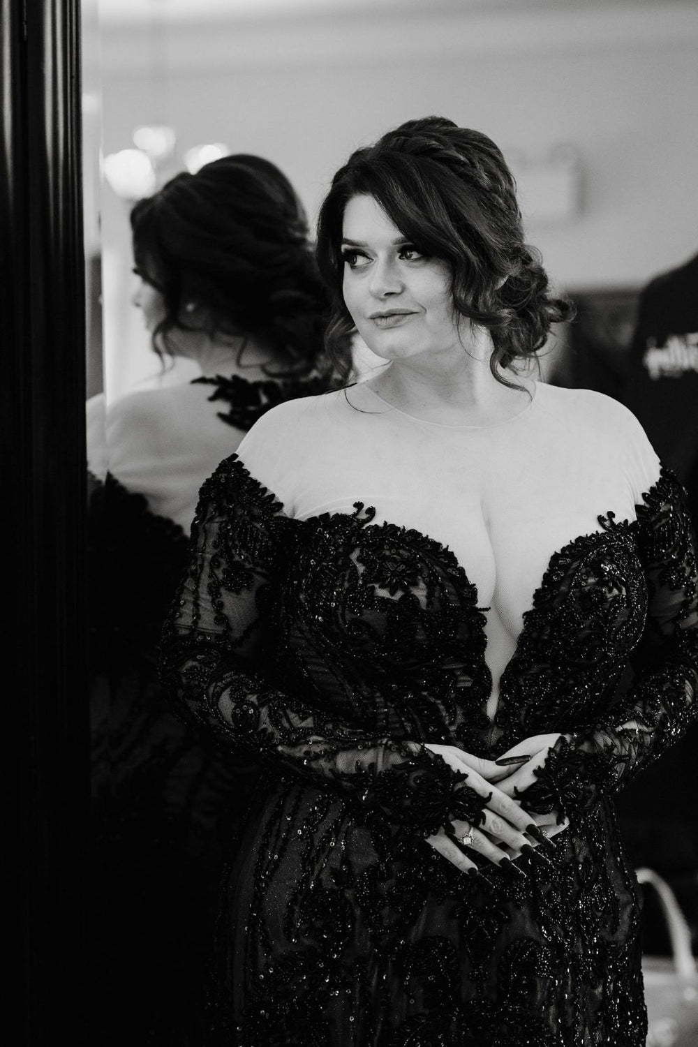 Black and white close-up portrait of bride in the Kati gothic wedding gown by Angela Kim Couture —  deep plunging V neckline with illusion tulle, intricate black lace beaded corset bodice, long sleeves