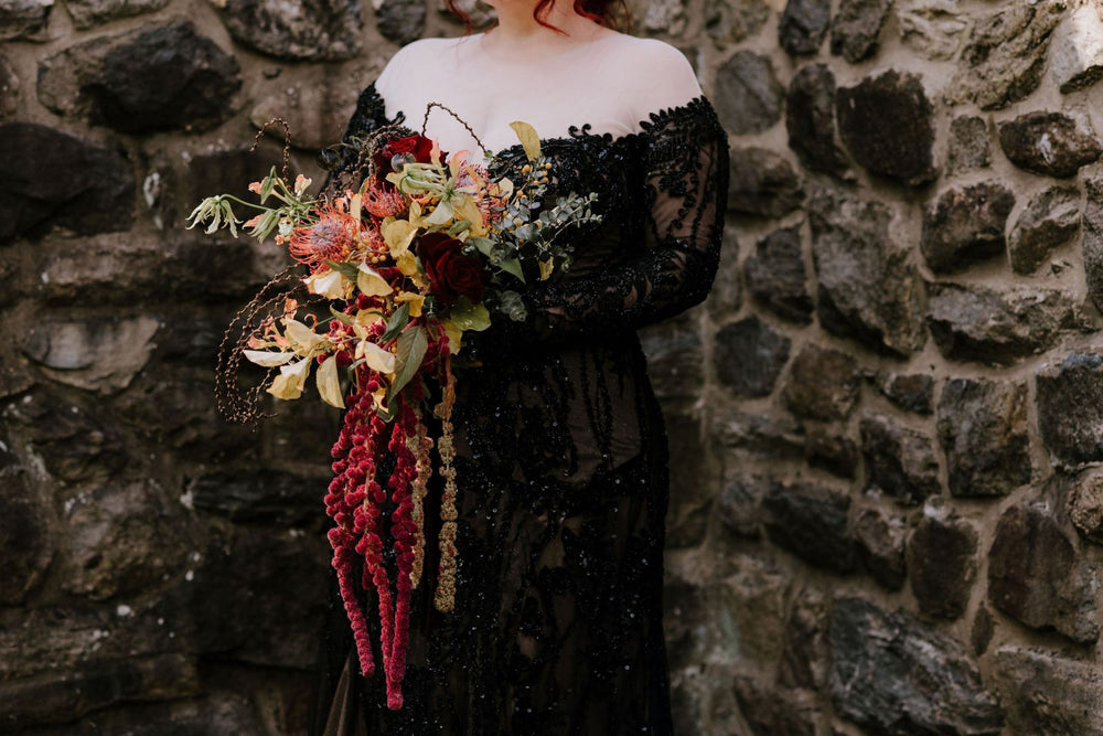 Bride in the Kati black lace gothic wedding gown by Angela Kim Couture. Dress features illusion neckline and off shoulder long sleeve