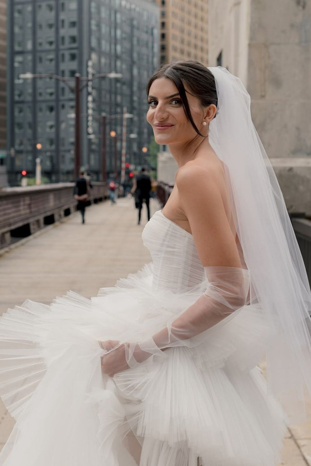 Side profile of the Rachel couture wedding dress highlighting the slim A-line silhouette and pleated tulle tiers