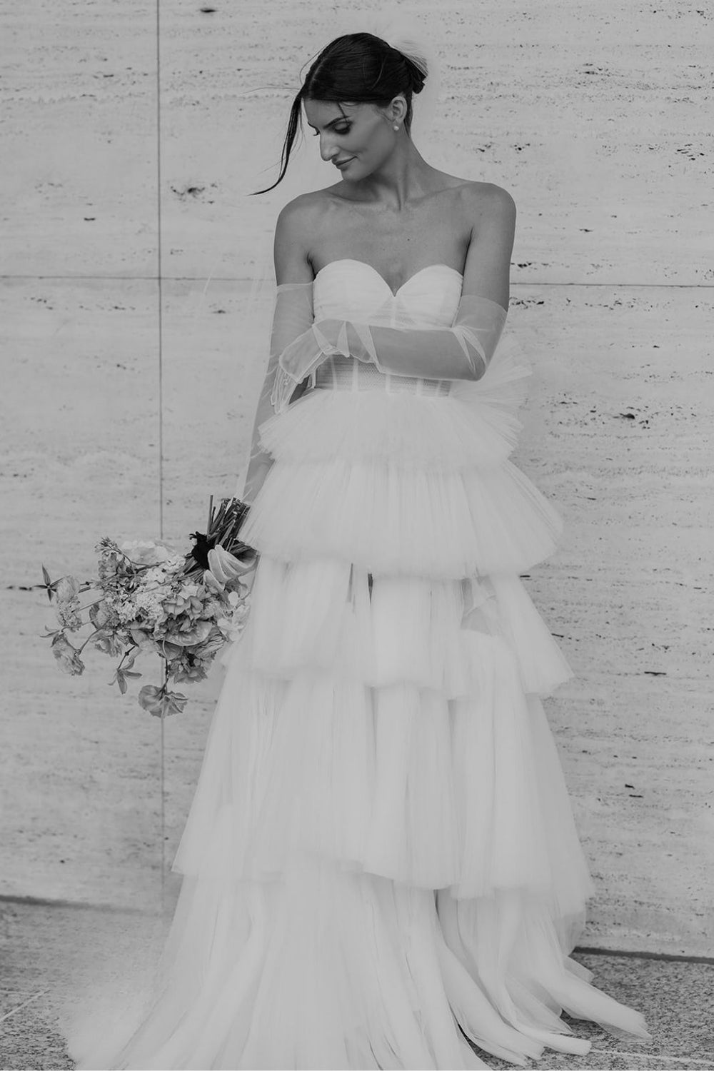 Full-length portrait of bride wearing the Rachel strapless bustier wedding dress with hand-pleated tiered tulle A-line skirt