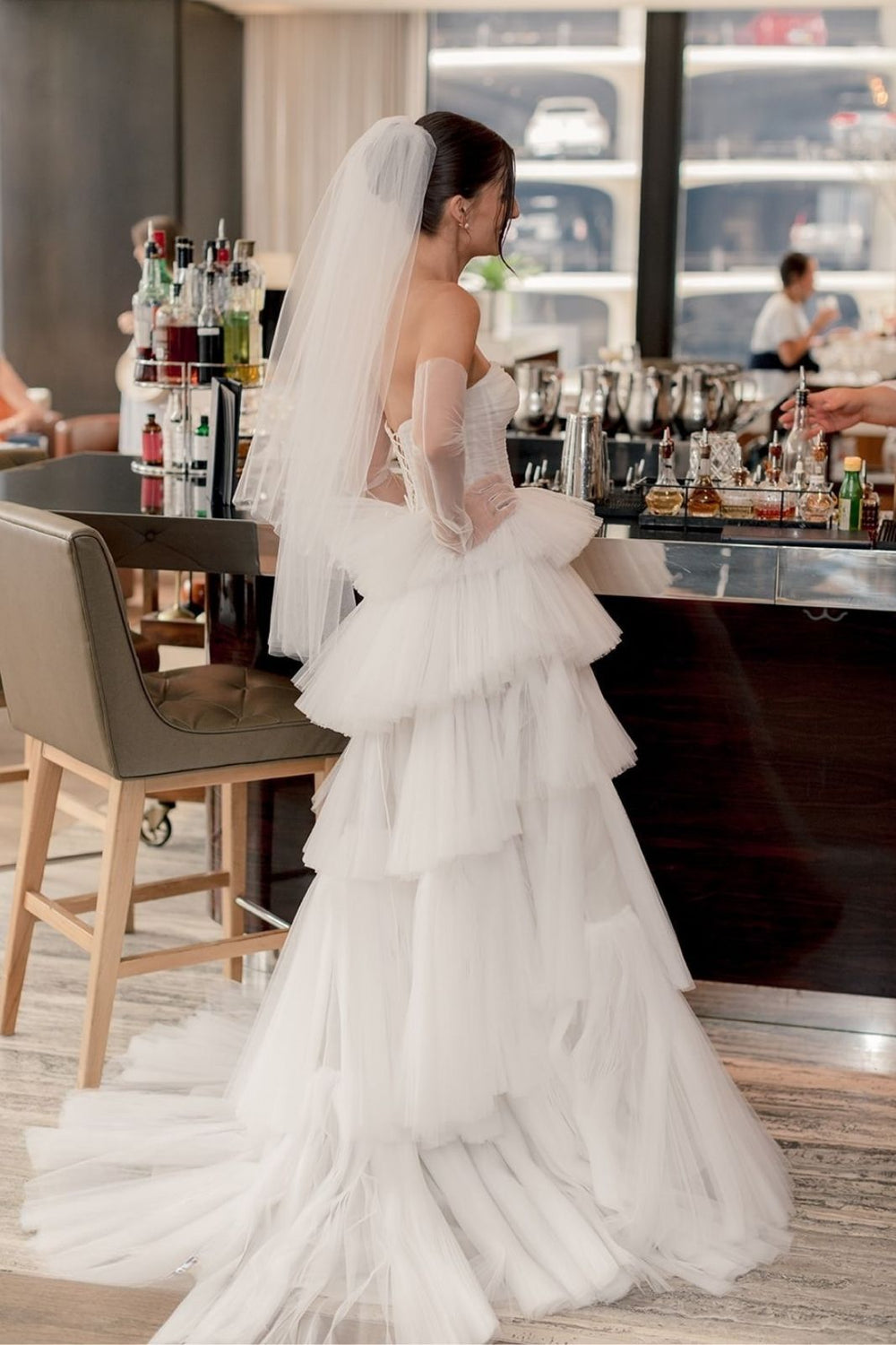 Full-length view of the Rachel strapless couture wedding gown with graduated tiered tulle skirt and chapel train