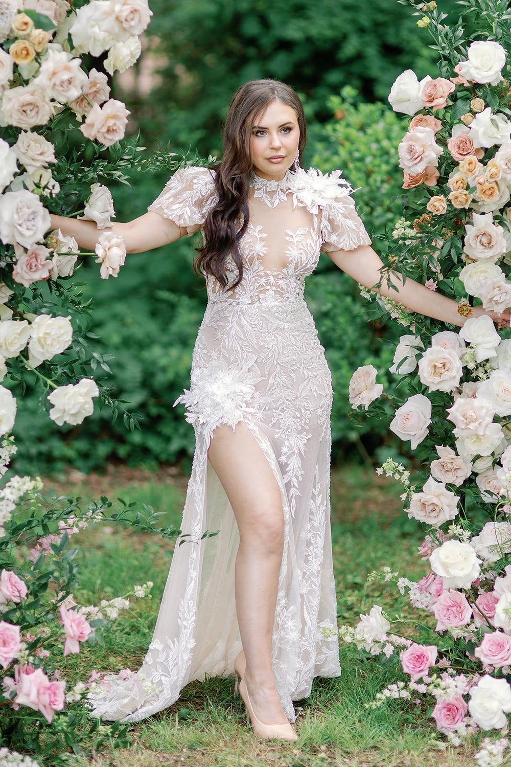 Full-length portrait of bride wearing the Rhea wedding dress with illusion bodice, plunging sweetheart neckline and statement puff sleeves