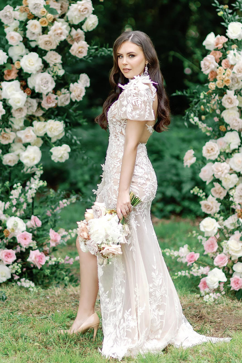 Side profile of the Rhea mermaid silhouette wedding dress showing the figure-hugging fit and high slit skirt