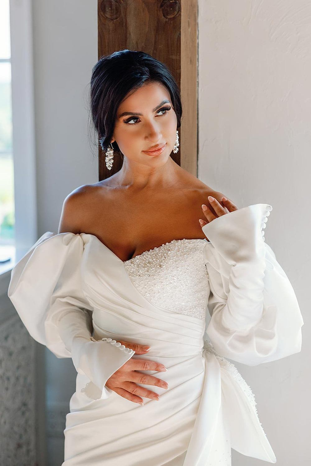 Close portrait of bride in the Veronica hand beaded short wedding dress by Angela Kim Couture, featuring a sweetheart neckline, elegant updo hairstyle, and crystal cluster drop earrings 