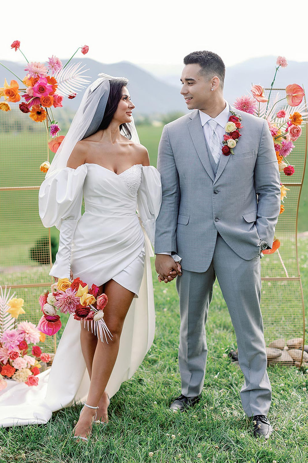 outdoor ceremony showing the Veronica short wedding dress by Angela Kim Couture with the removable beaded train sweeping across the lawn.
