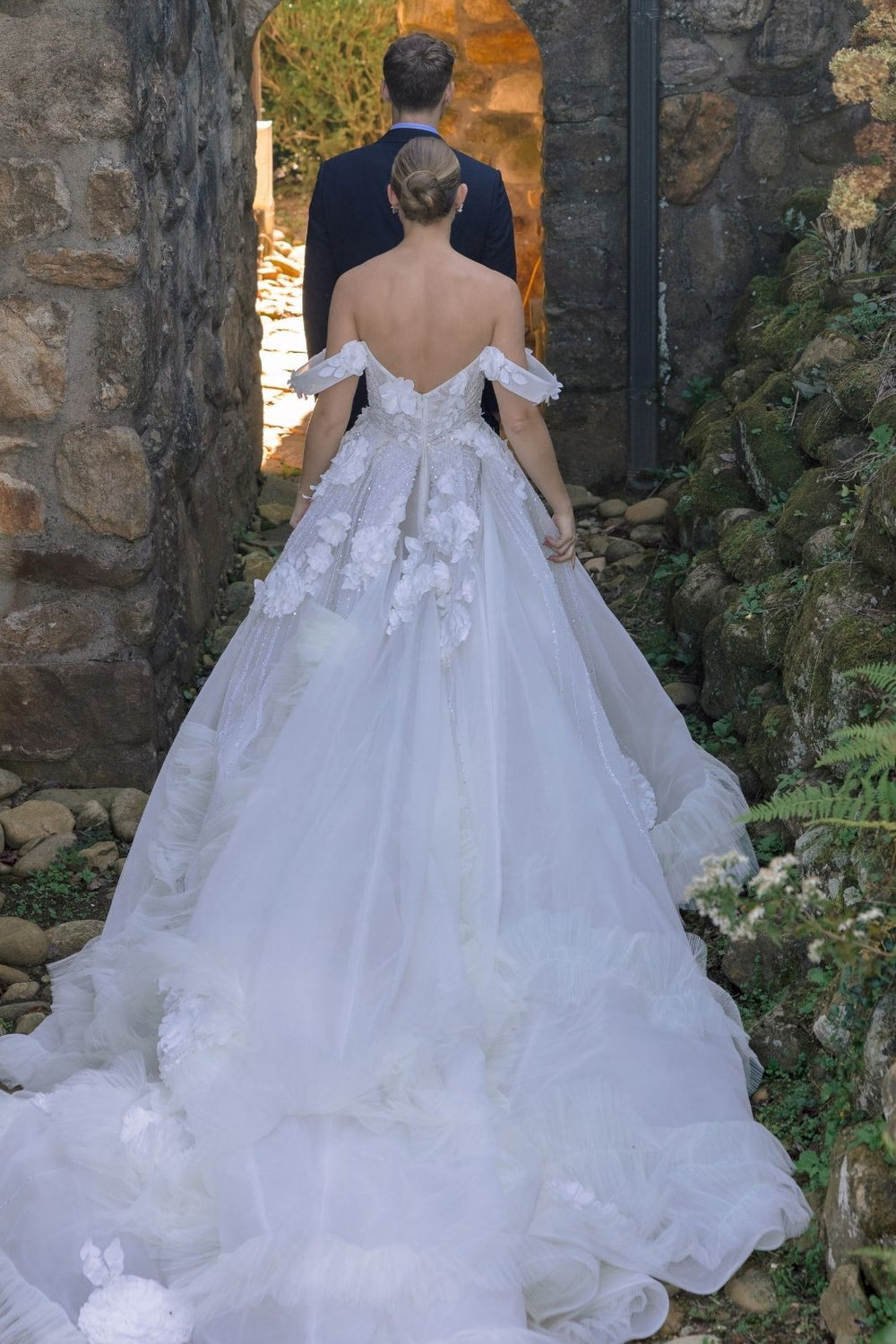 The Allure bridal gown captured in motion, showcasing the flowing ball skirt and dramatic train movement