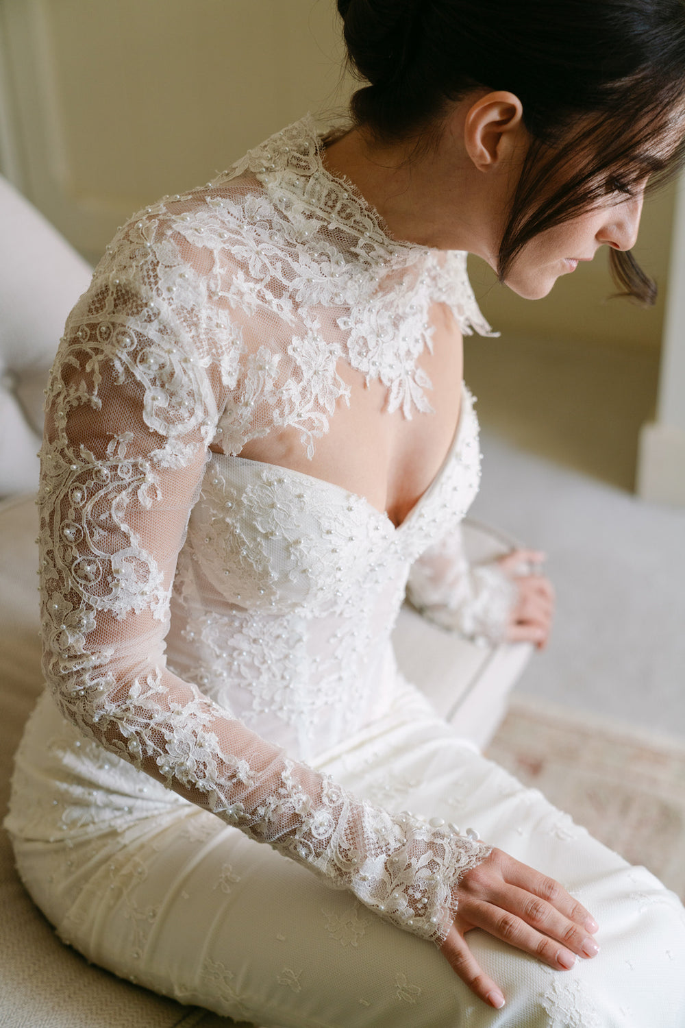 Detail of Blaire's bespoke sheer lace bolero by Angela Kim Couture showing the elegant high neckline, intricate floral lace shoulder, and hand-placed pearl embellishments