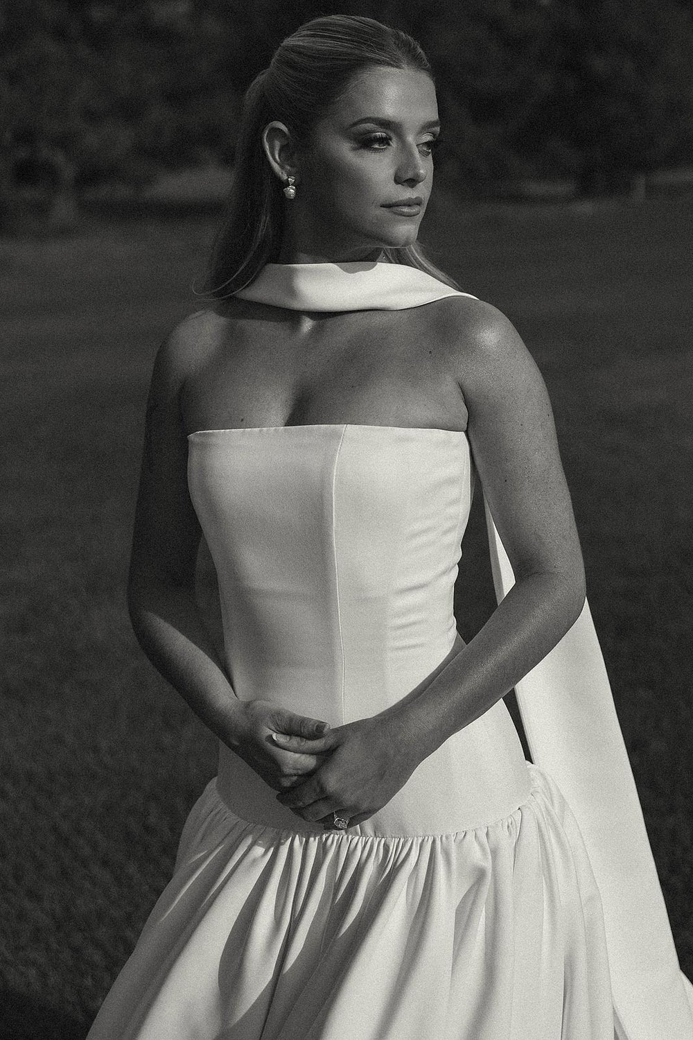 Close portrait of bride Hannah in her custom strapless crepe wedding dress by Angela Kim Couture, showing the elegant draped silk neck veil and drop waist bodice with her sleek low ponytail bridal hairstyle