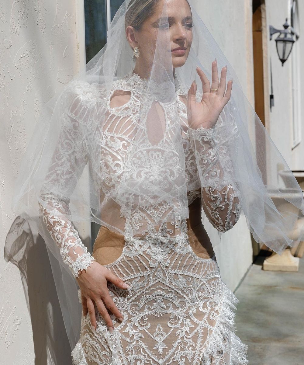 Elegant portrait of an Angela Kim Couture bride wearing a flowing cathedral veil, and custom-designed bridal gown with puff shoulder detail