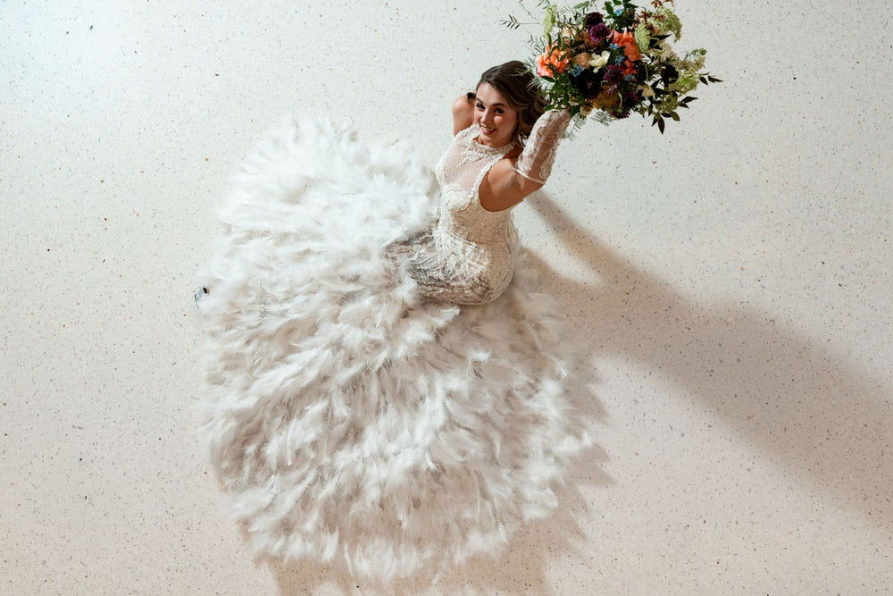 The Ayla couture wedding dress captured in motion, showcasing the flowing feather train and sleek mermaid silhouette