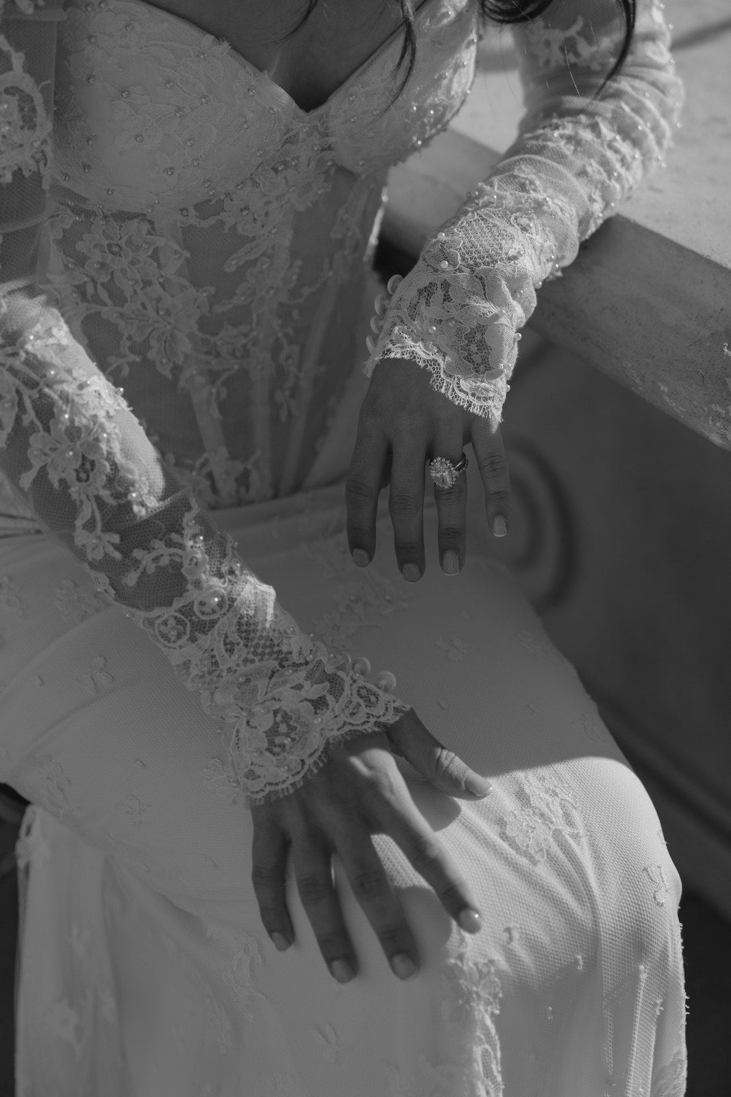 Close-up of a couture lace wedding dress with long sleeves.