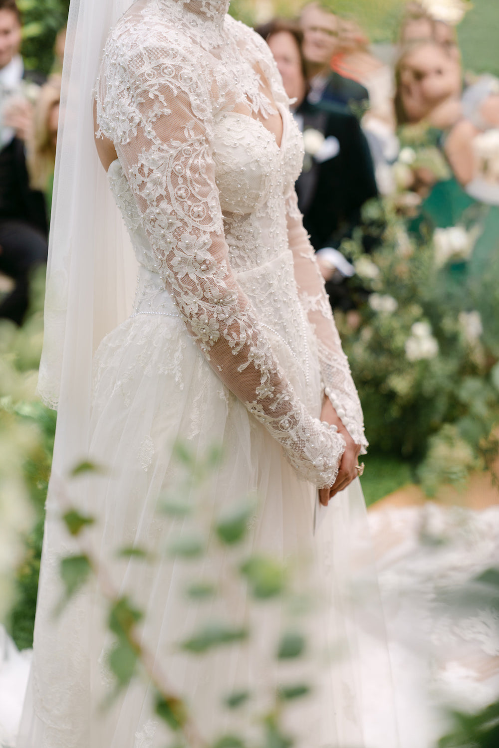 Intimate detail shot of Blaire's custom lace bolero pearl-trimmed cuff by Angela Kim Couture with overskirt tulle in the background