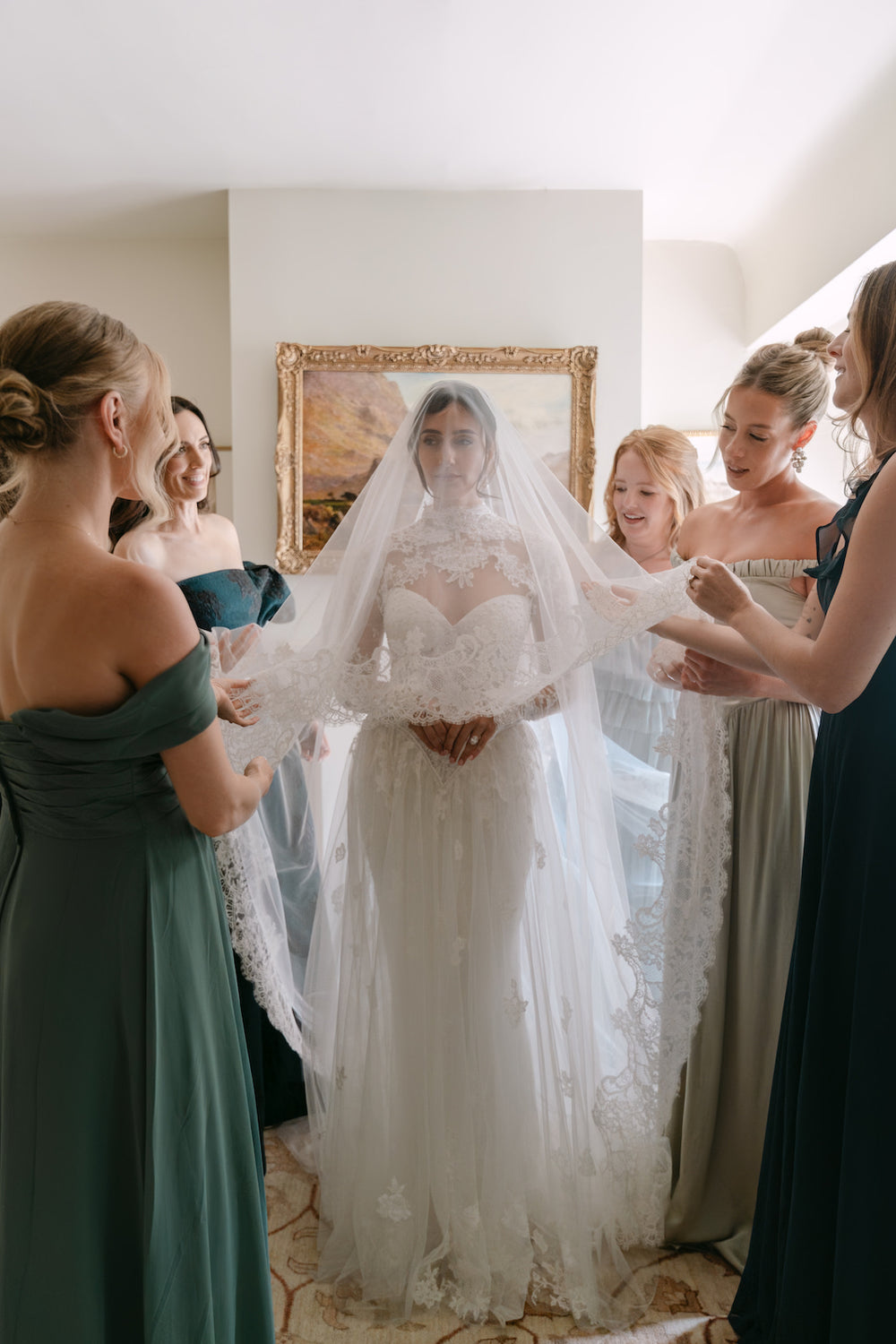 Bride Blaire surrounded by bridesmaids showing the elegant detail of the cathdrel lace veil designed by Angela Kim Couture