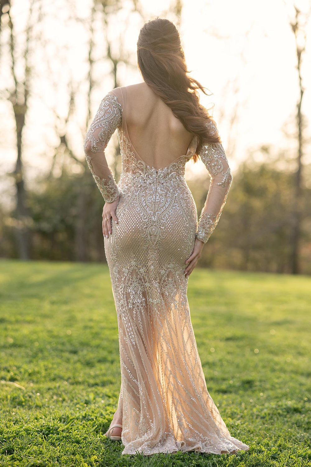 Back view of the Evelina gold illusion couture dress highlighting the bare back and flowing train