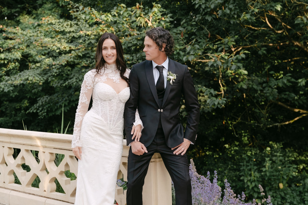Blaire's custom Chantilly lace bolero and dress by Angela Kim Couture showing delicate hand-finished pearl embellishments against a lush garden