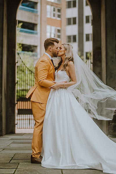 Elizabeth and Jacob kissing in their wedding photo.