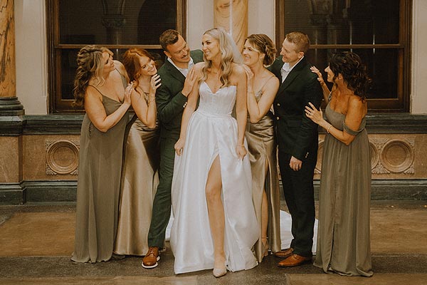Elizabeth in her custom bridal gown posing with her wedding party.