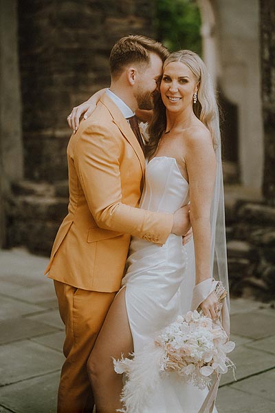 Elizabeth in her custom wedding dress posing with Jacob for a wedding portrait.