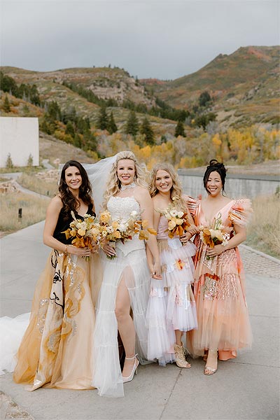 Kaitlin posing in her wedding dress with her bridesmaids.