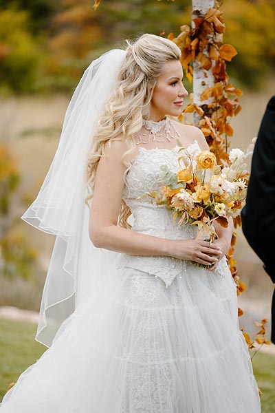 Kaitlin holding a bouquet at her wedding ceremony.