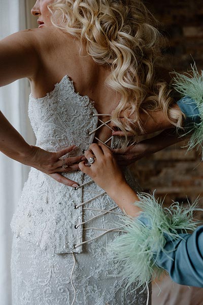 Lacing up the back of Kaitlin's custom wedding dress.