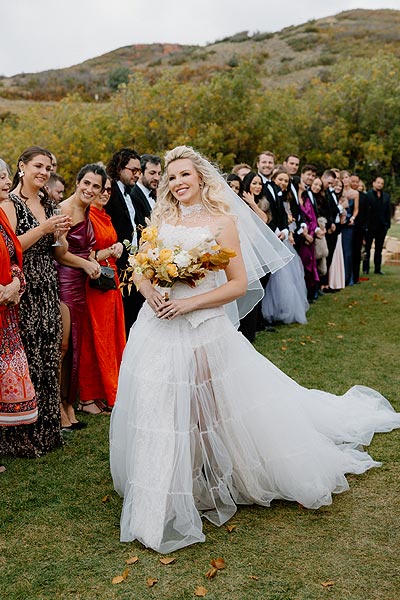 Kaitlin in her custom wedding dress wlaking the aisle.