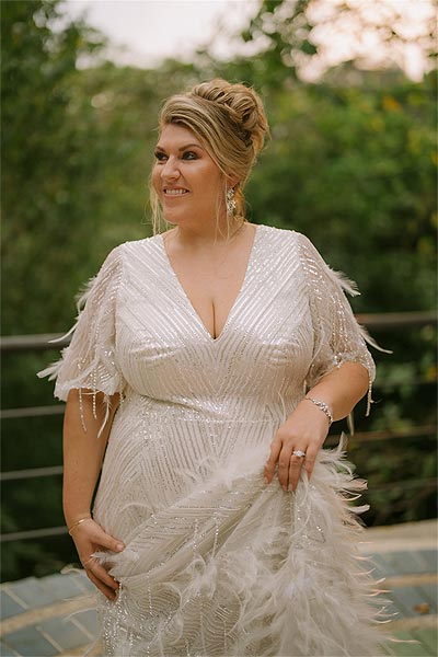 Leah's beautiful custom wedding gown features a feathered skirt.