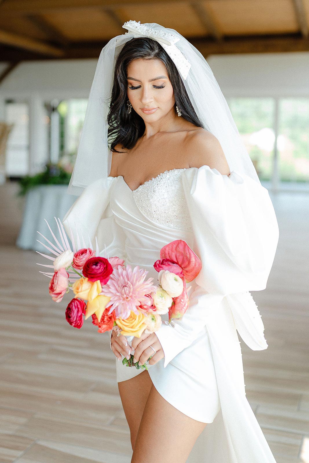 Veronica posing in a short wedding dress with Juliet sleeves