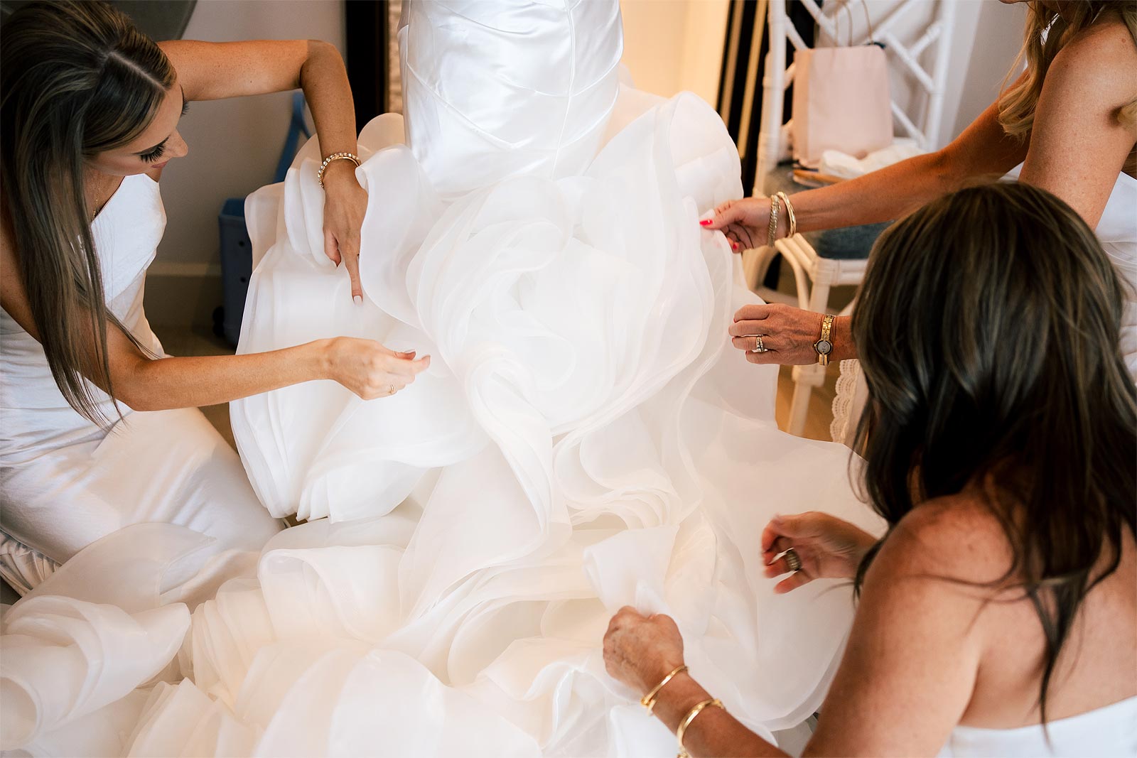 Bridesmaids hands on the wedding dress