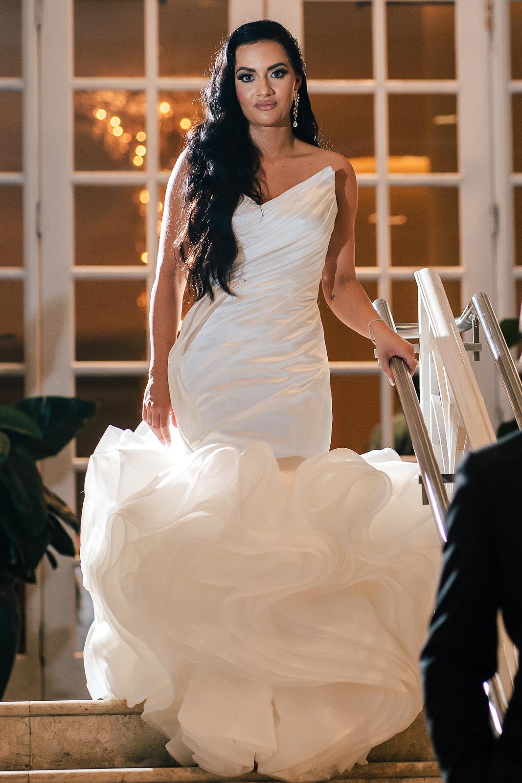 Chelsea descending some stairs in her wedding gown