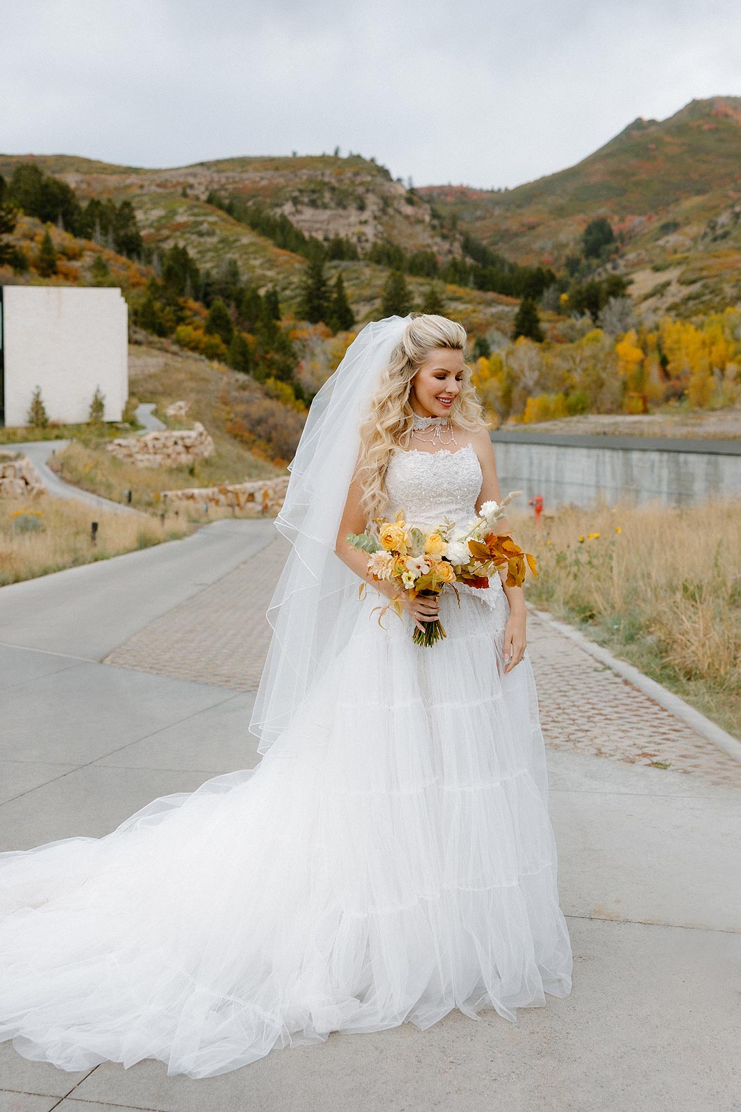 Kaitlin posing in her custom wedding gown featuring an embellished corset and tiered skirt.